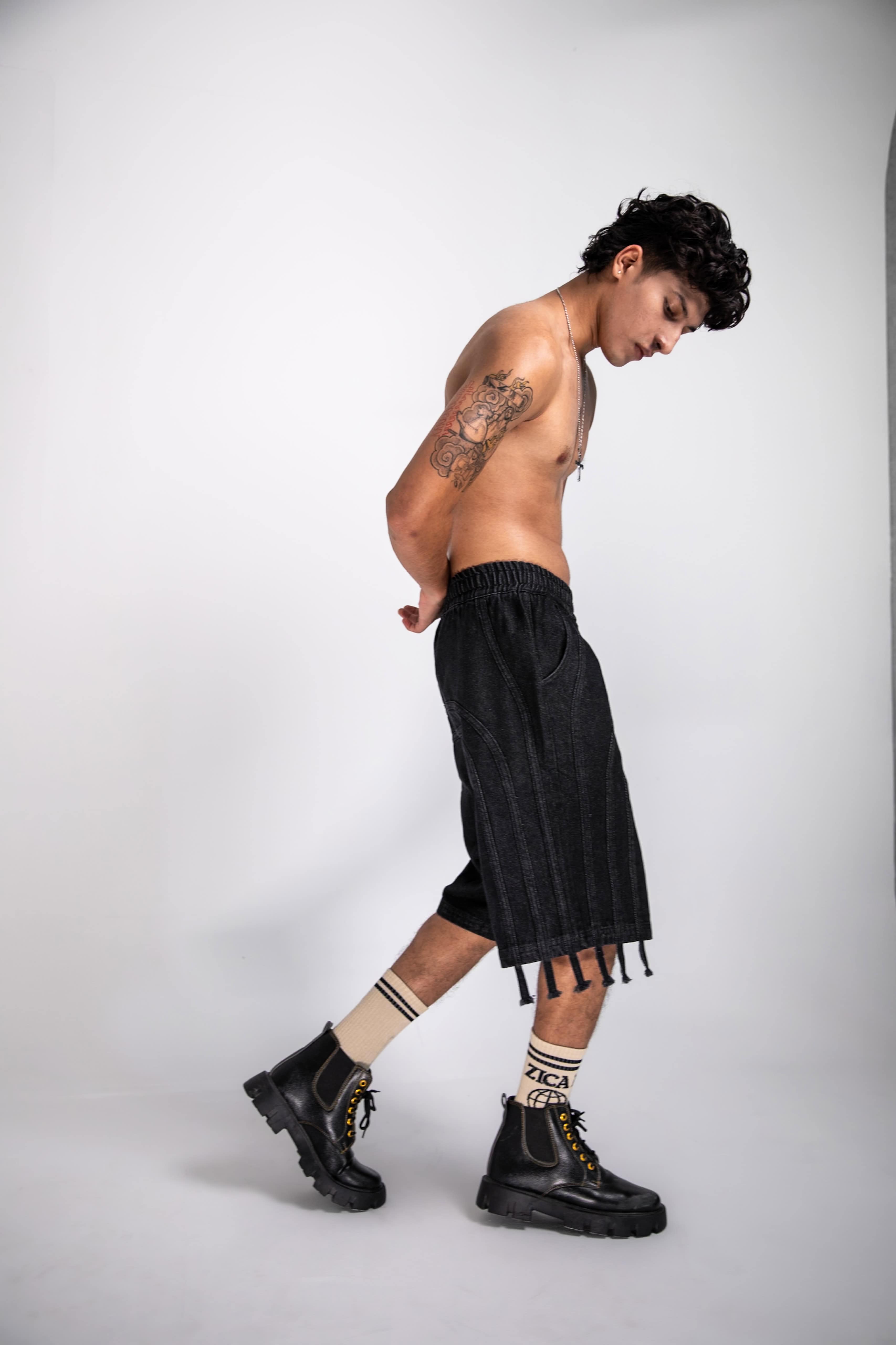 Black denim jorts with unique fringe details, perfect for urban street style