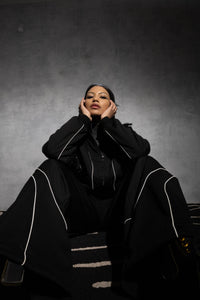 Man posing in black oversized tracksuit