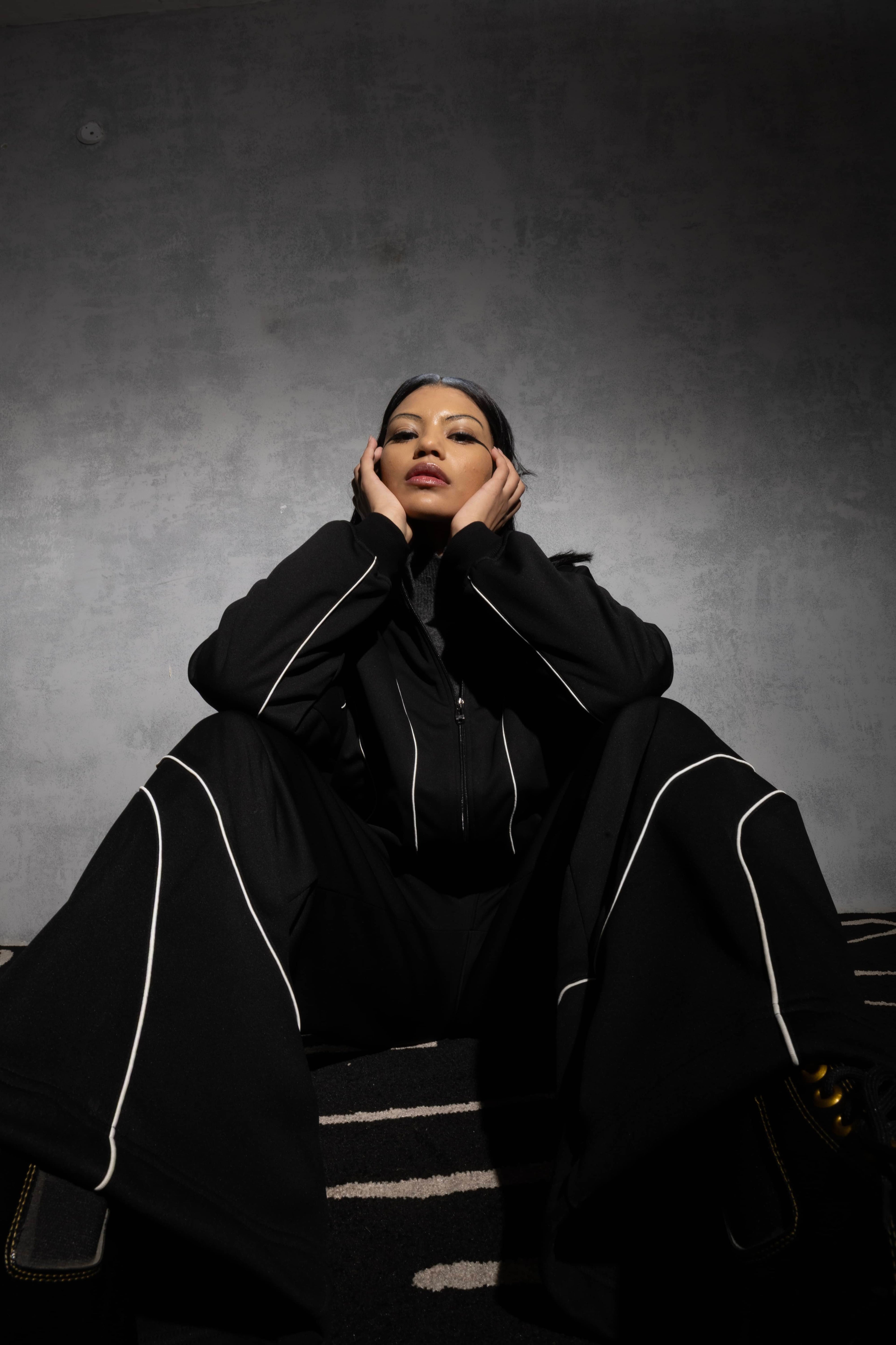 Man posing in black oversized tracksuit