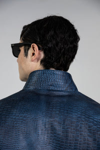 Close-up detail of blue crocodile embossed leather texture on the back