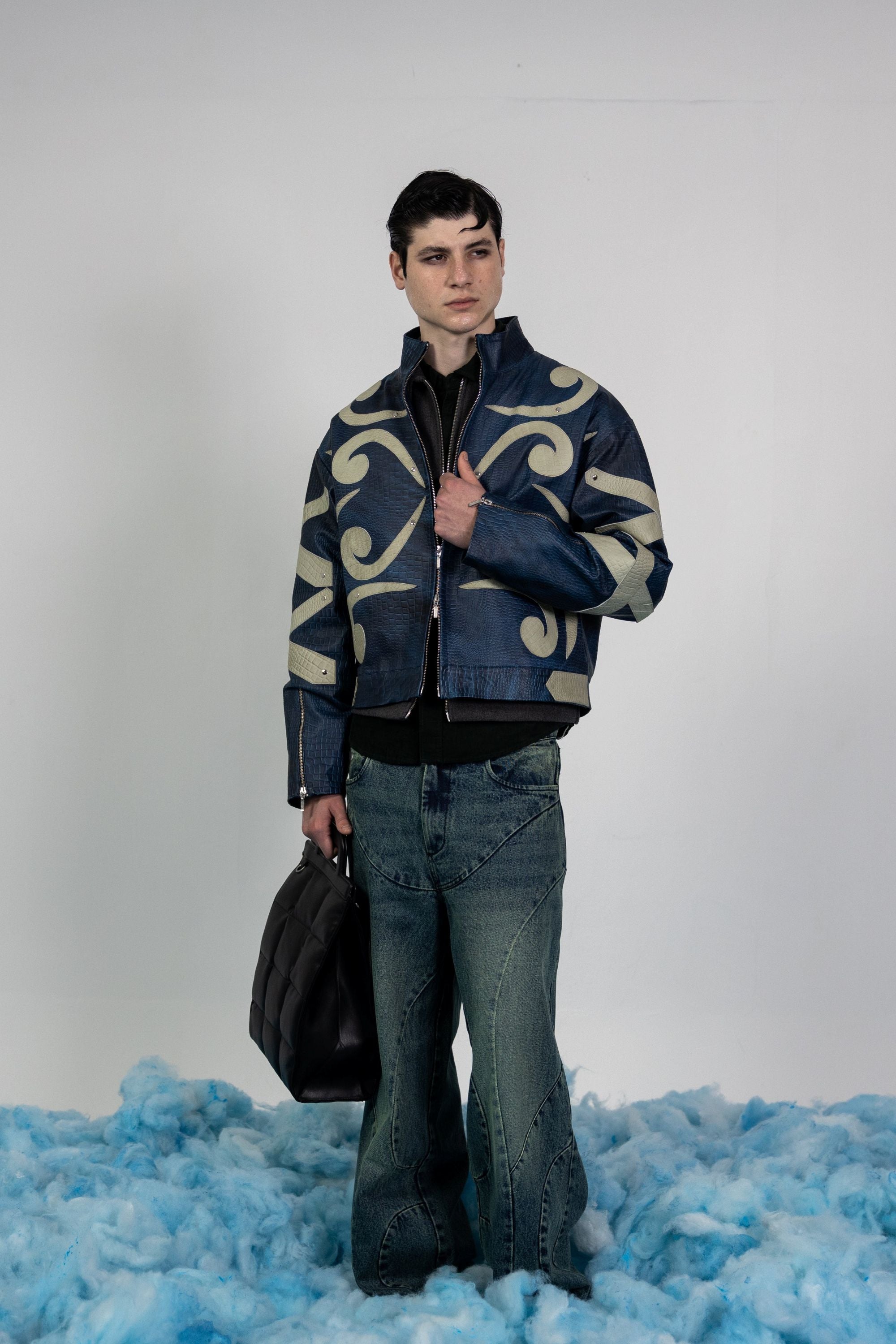 Full-length view of men's blue embossed leather jacket with beige appliqué