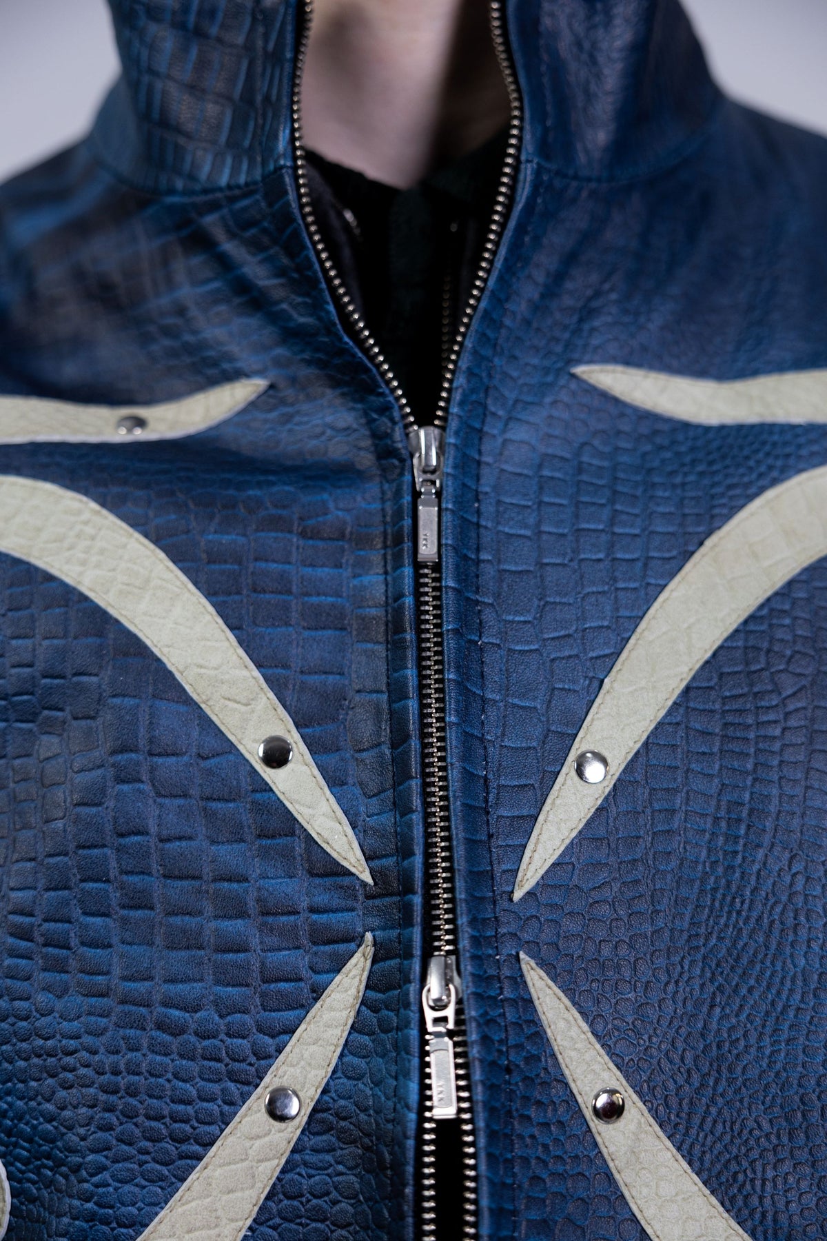 Close up of heavy duty metal front zipper on a premium blue embossed leather jacket