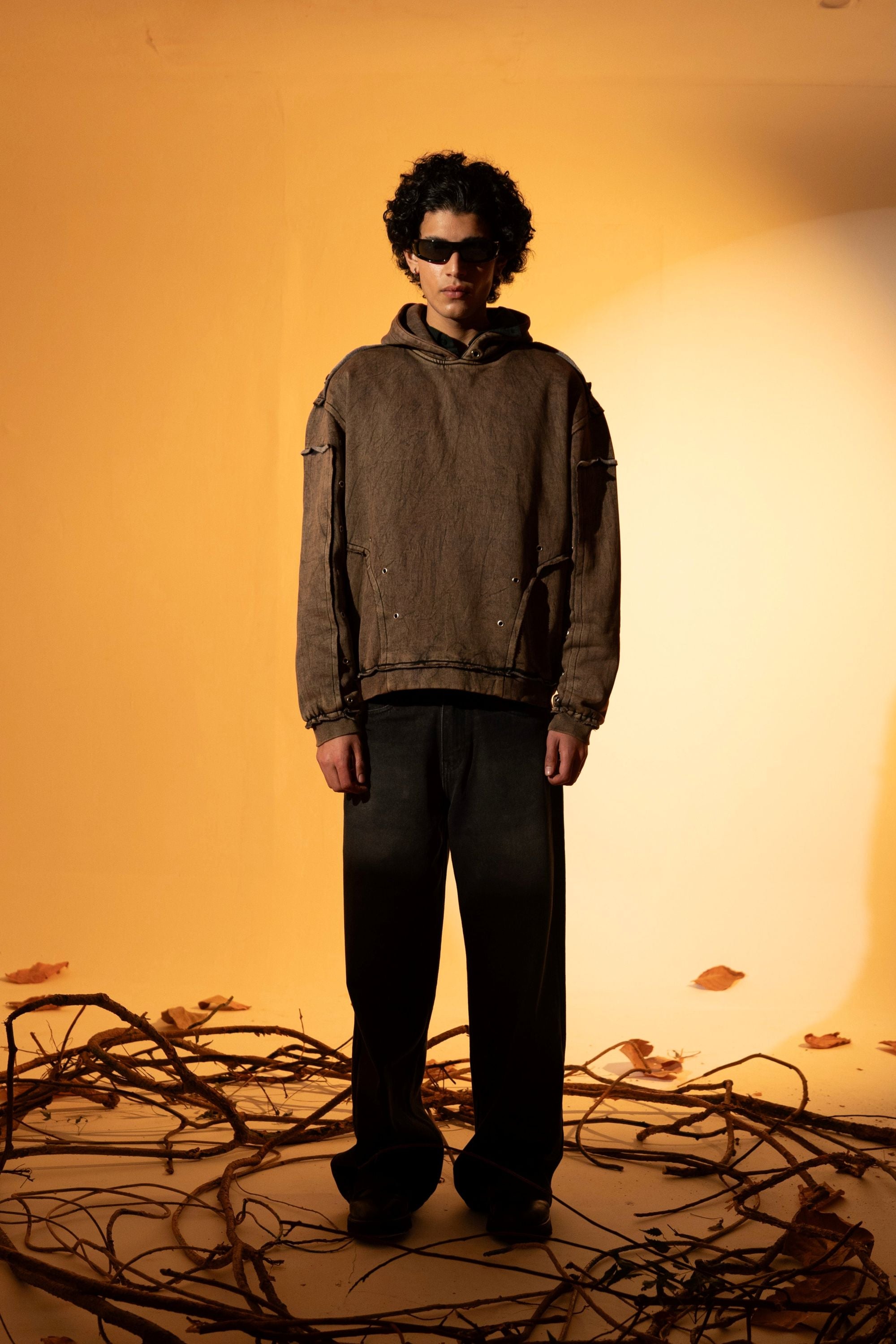 Brown cotton fleece hoodie featuring raw edges and a relaxed fit, with a minimal design