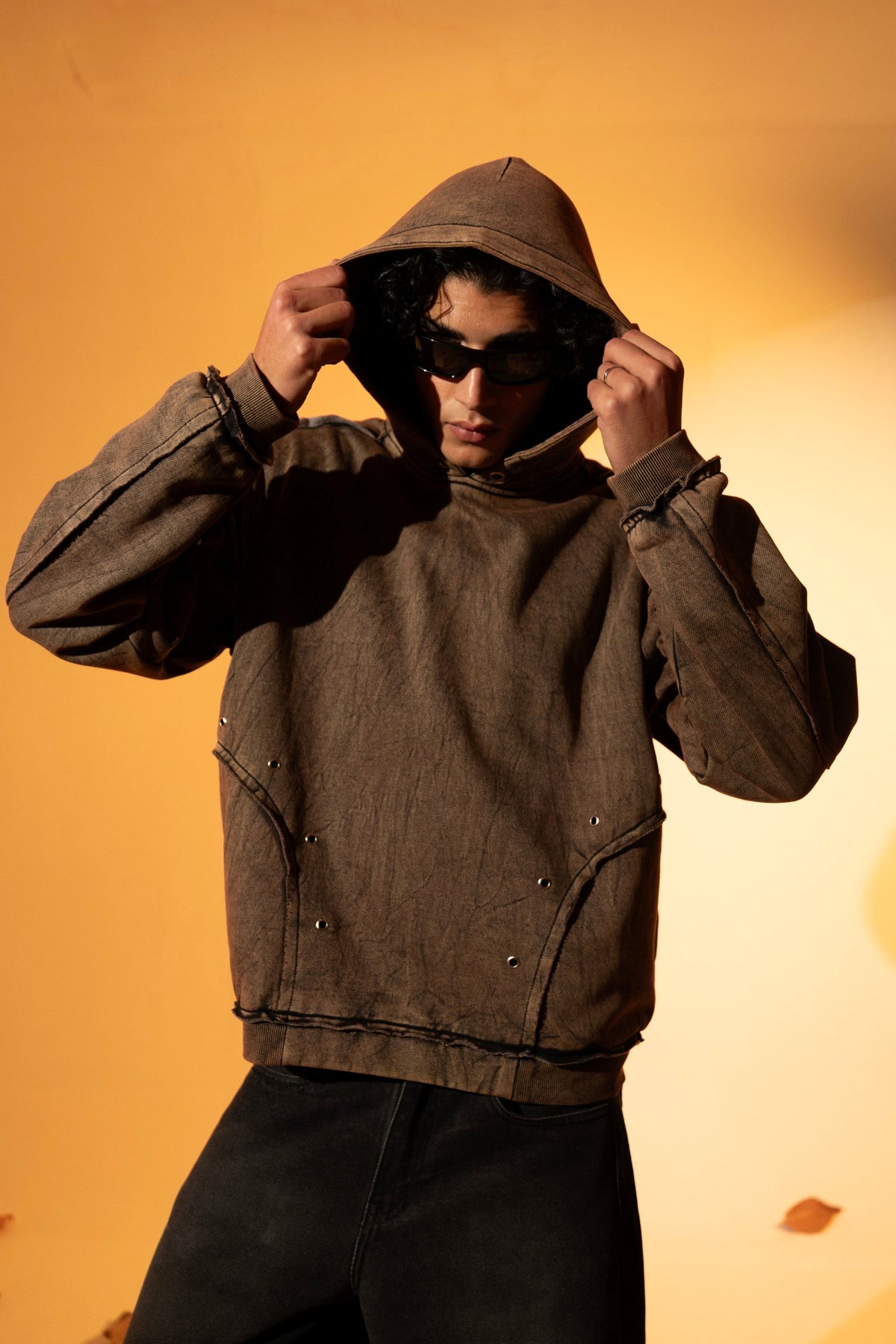 Brown cotton fleece hoodie with a loose silhouette and raw edge detailing along the hem