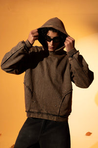Brown cotton fleece hoodie with a loose silhouette and raw edge detailing along the hem