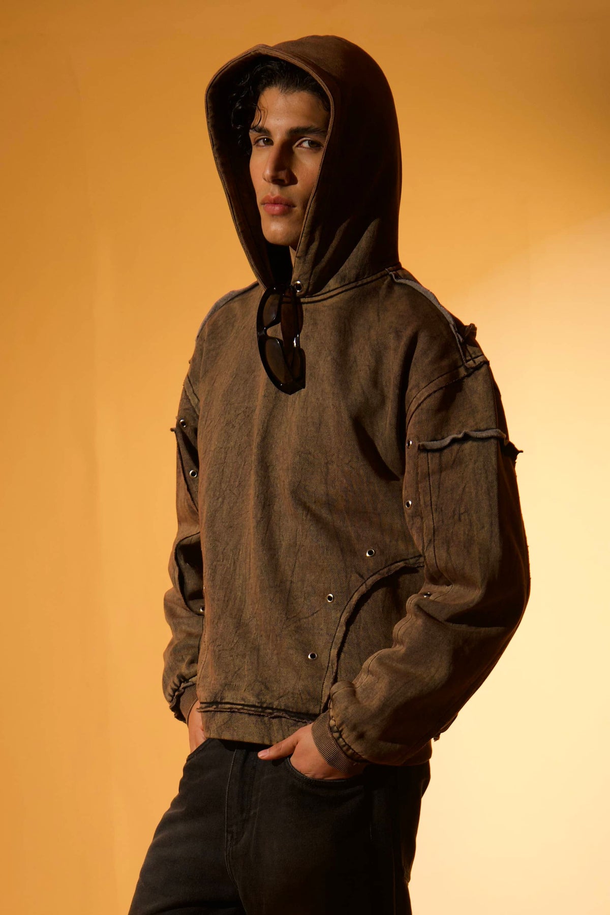 Brown cotton fleece hoodie with raw edge details, styled for a relaxed, effortless urban look