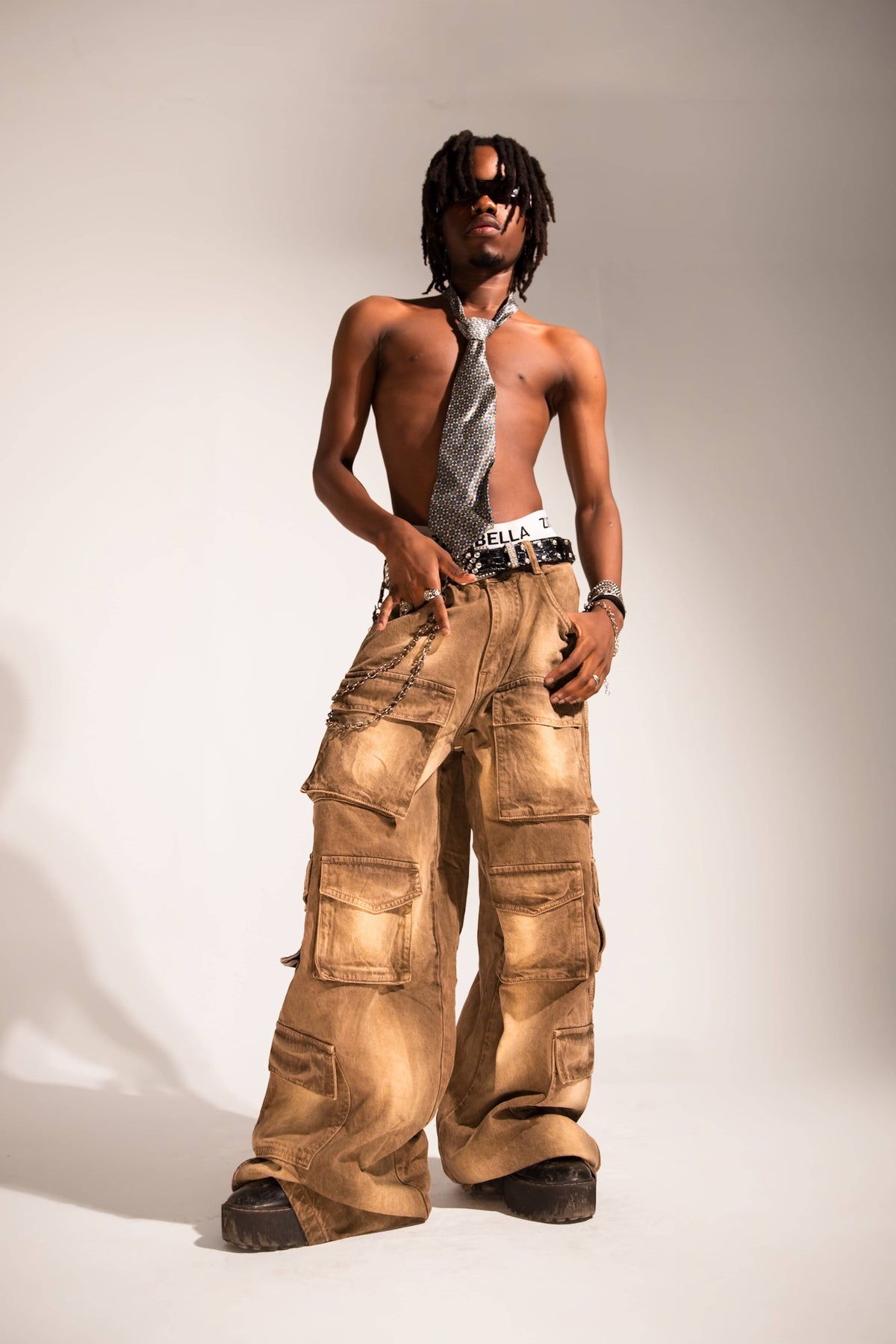 brown distressed denim cargo pants with a baggy streetwear fit and multi-pocket utility structure