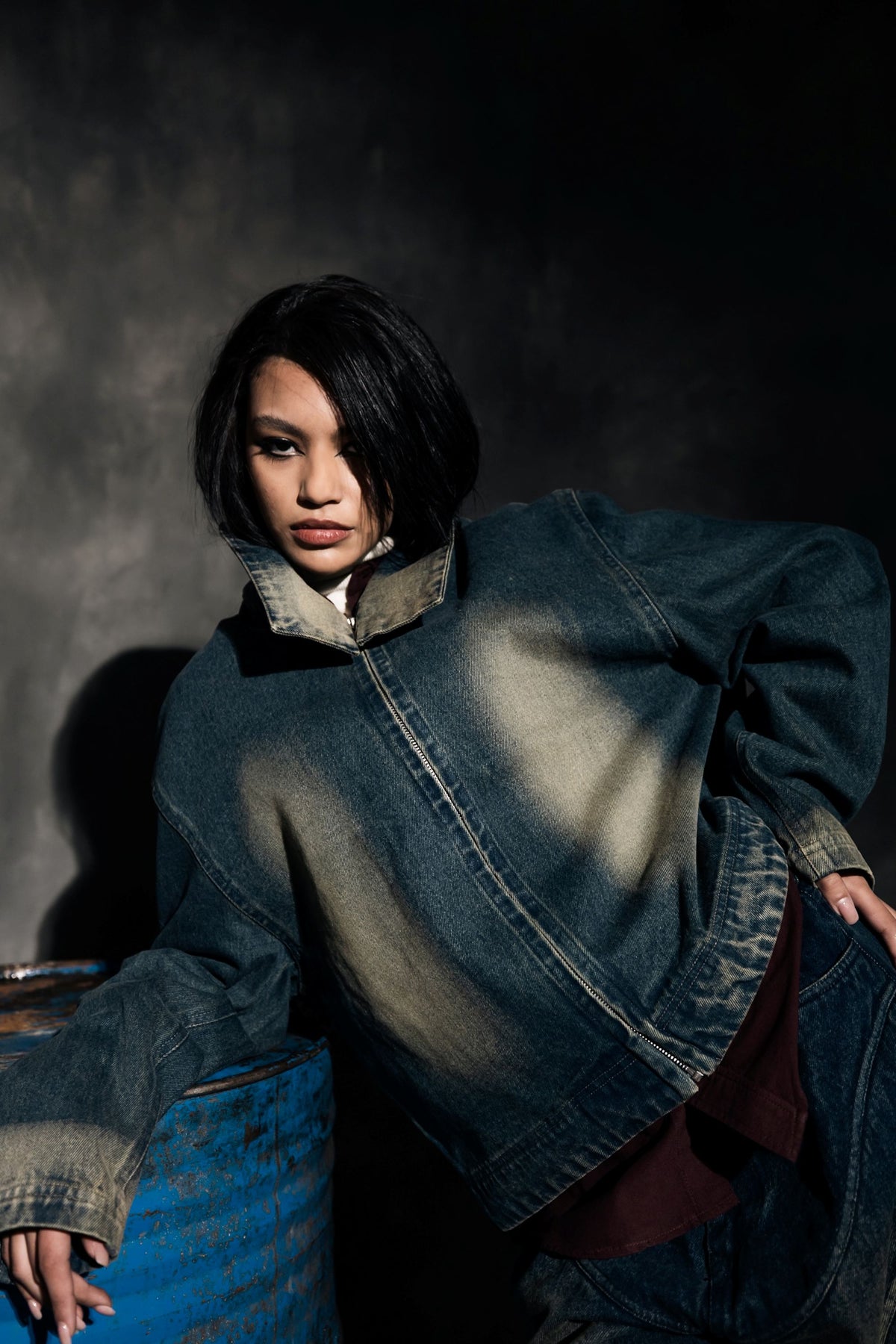 Angled view of denim jacket highlighting fabric texture and structural design