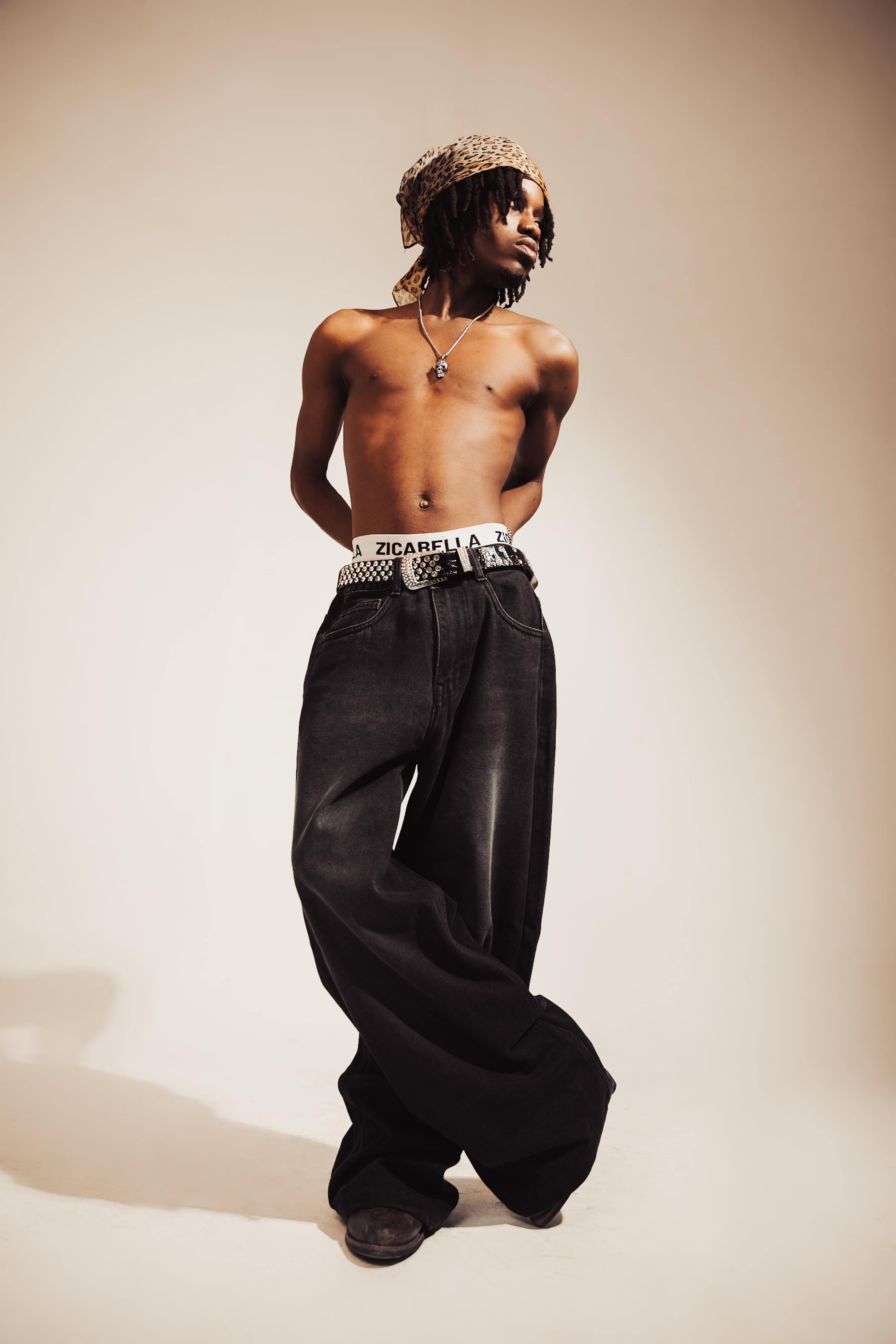 Black denim jeans with a relaxed fit and subtle embroidered details, offering a refined streetwear aesthetic