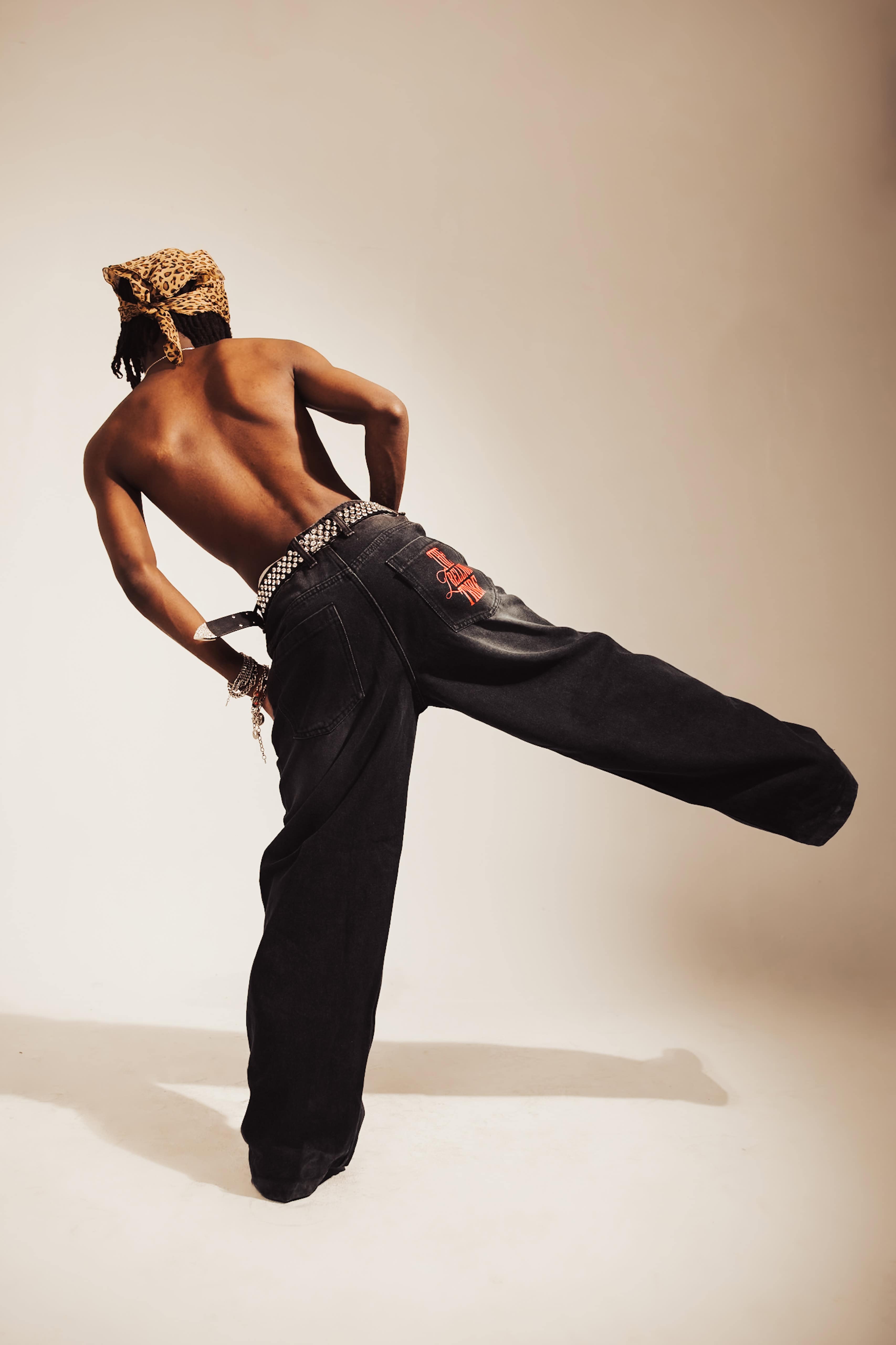 Structured black denim jeans with a relaxed fit and distressed accents, perfect for a premium streetwear look