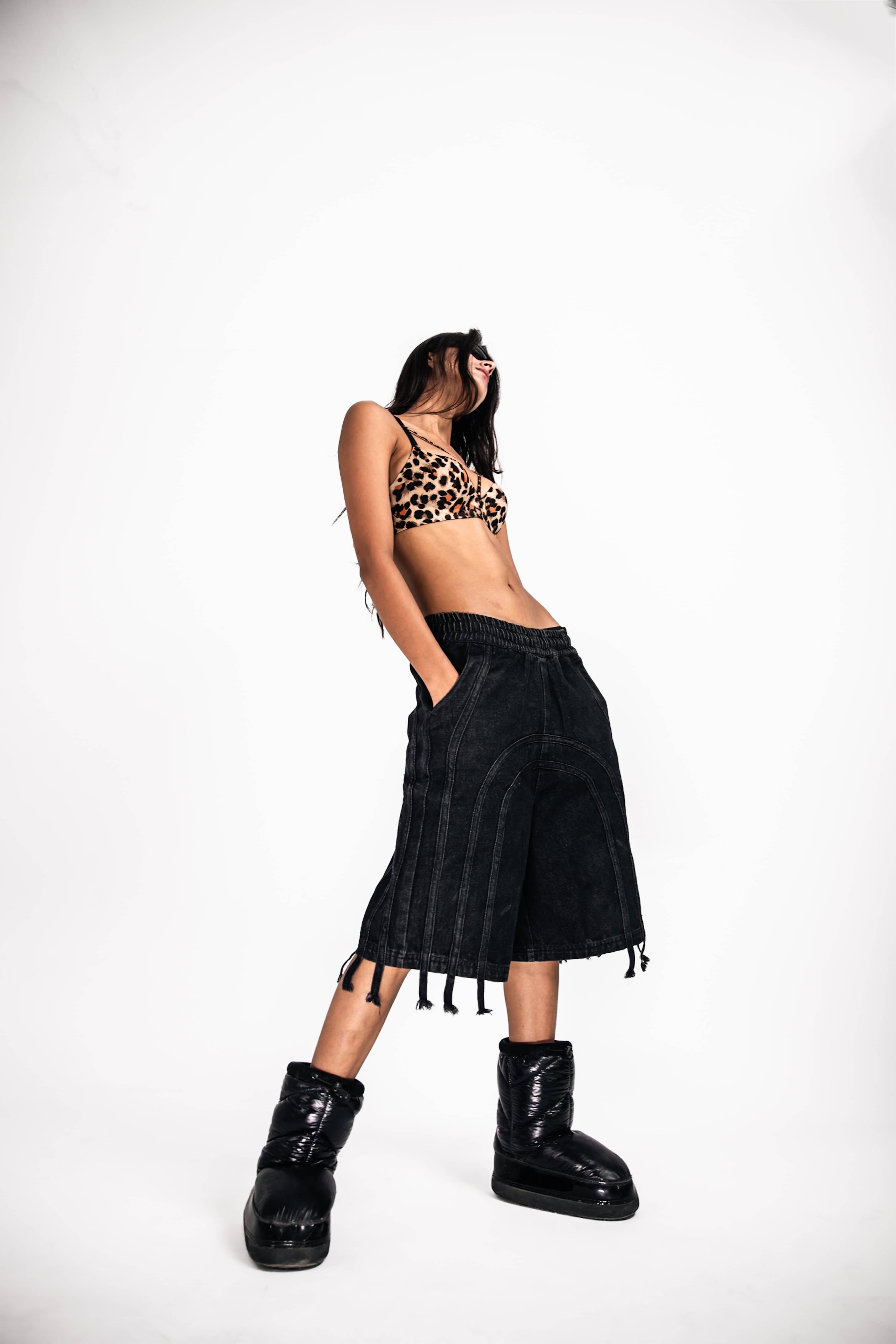 Trendy black denim jorts with fringe, a must-have streetwear piece