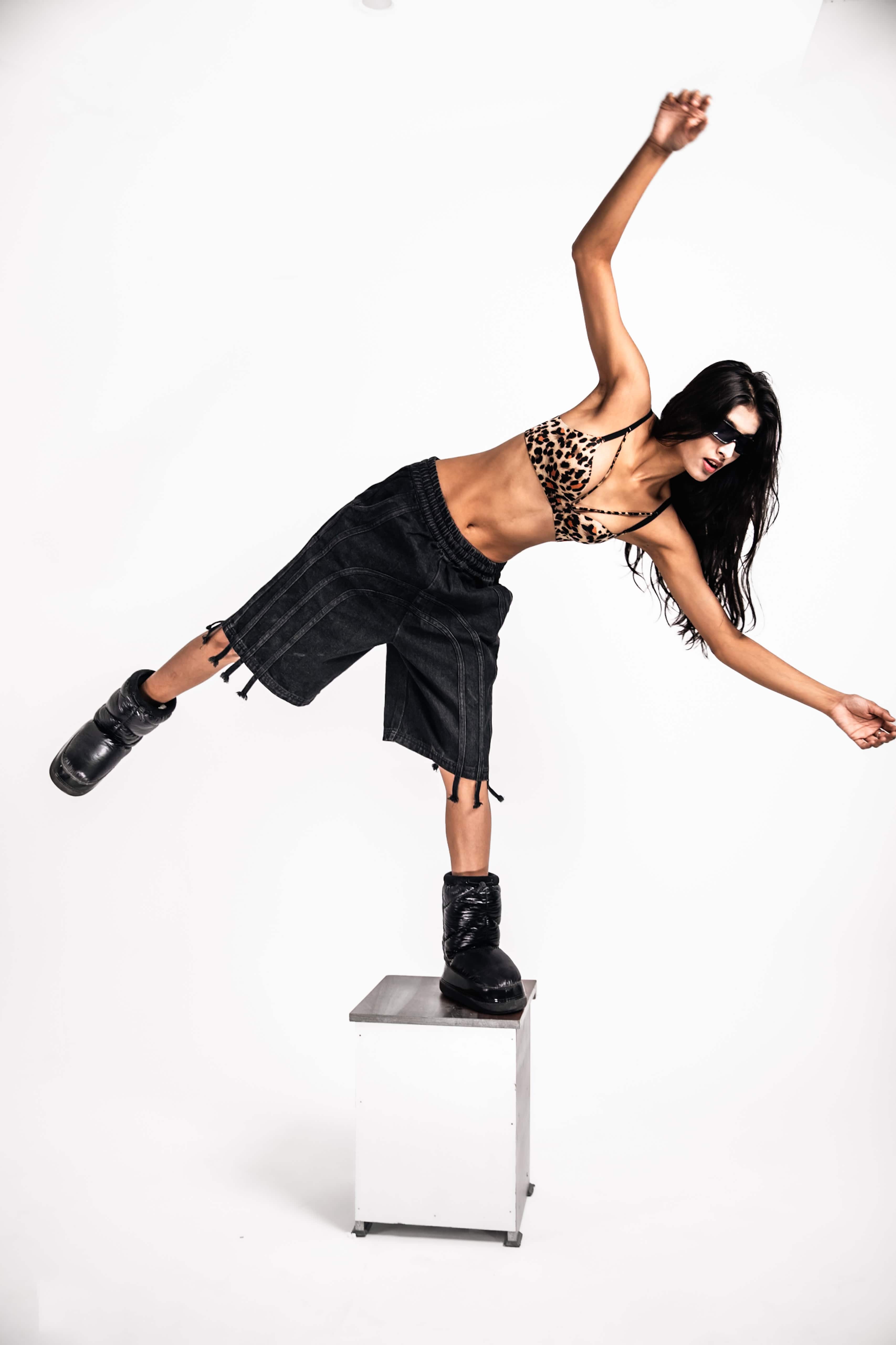 Full length shot of denim jorts, styled with fringe for a modern streetwear look