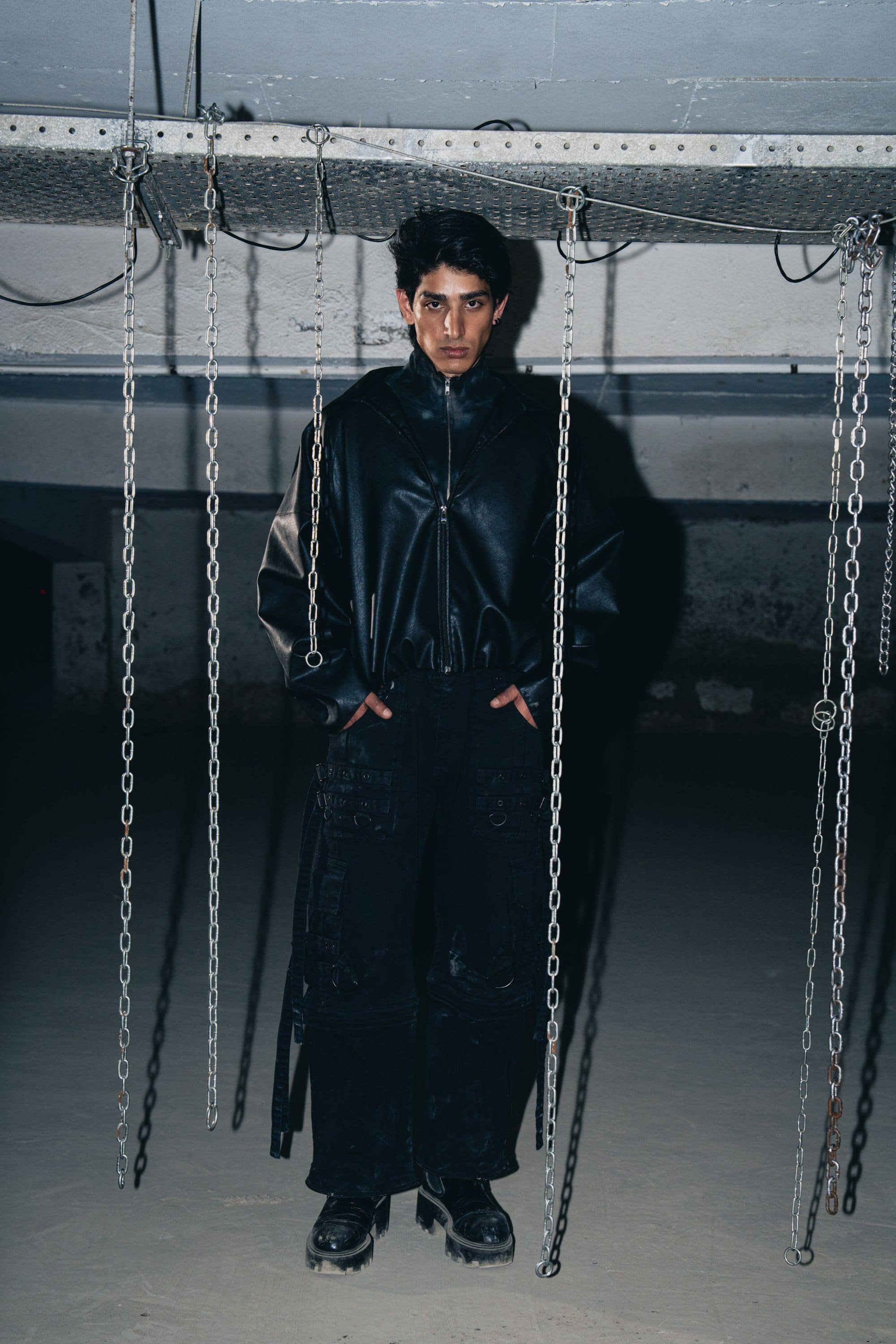 Minimalist black leather jacket with a textured finish, designed for a relaxed fit and modern biker look