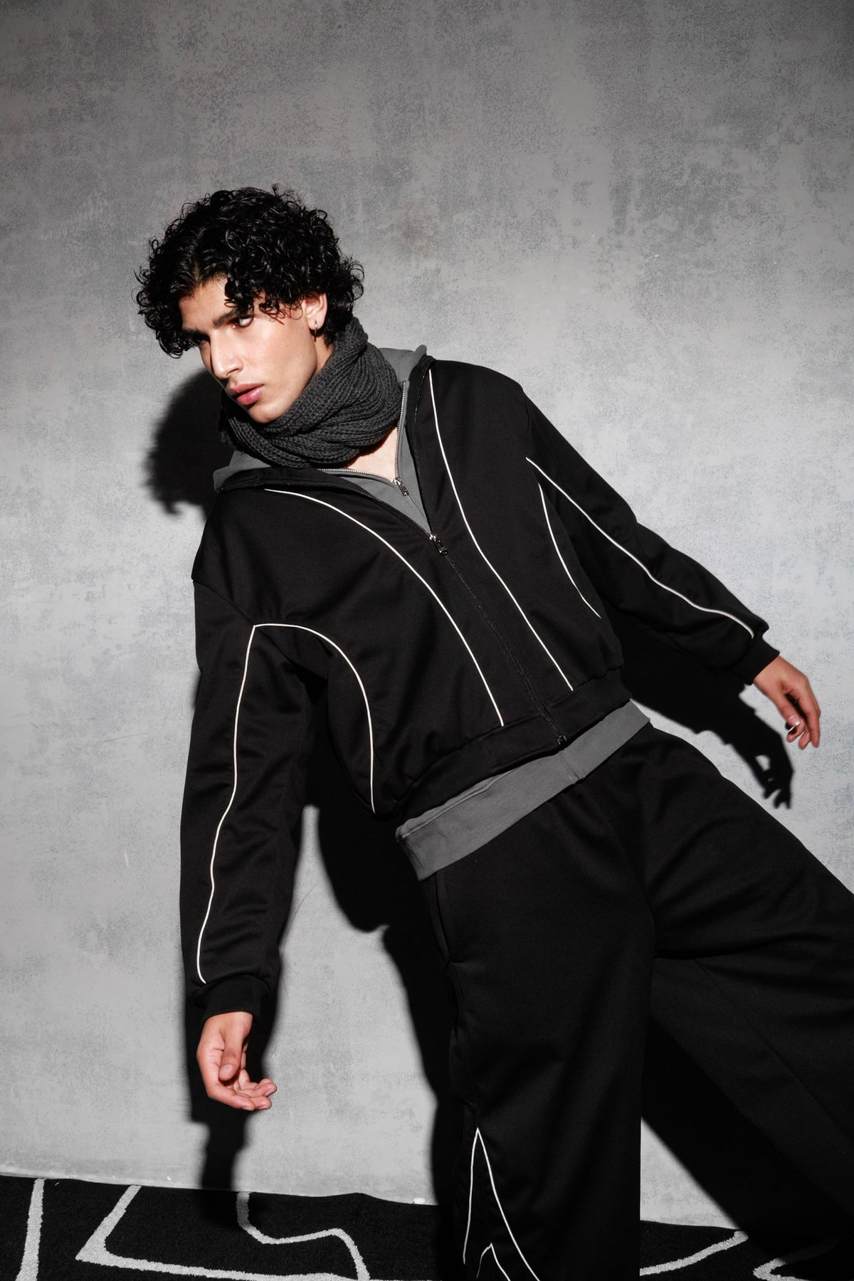 Model wearing black oversized tracksuit in modern streetwear style