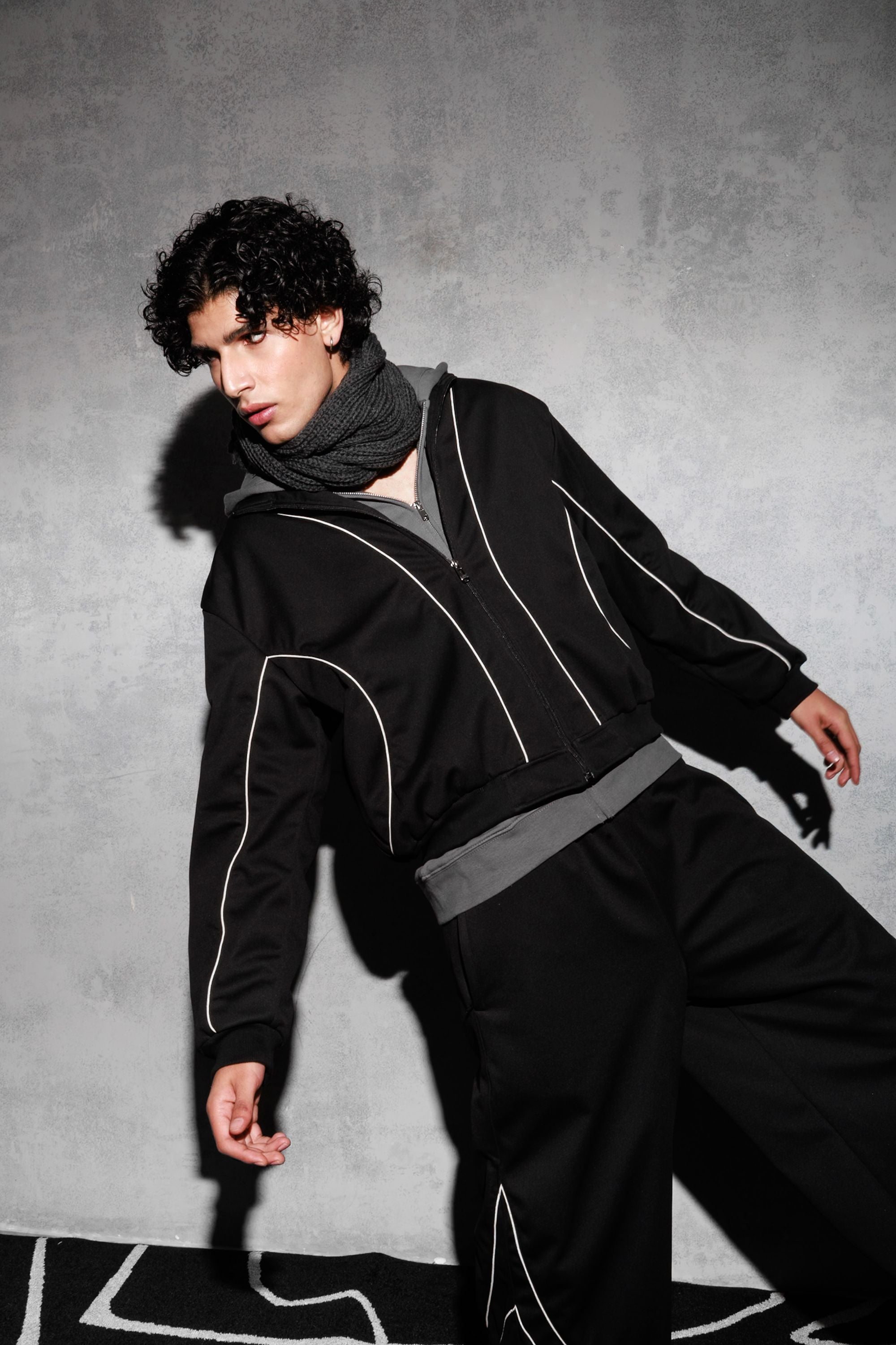Model wearing black oversized tracksuit in modern streetwear style
