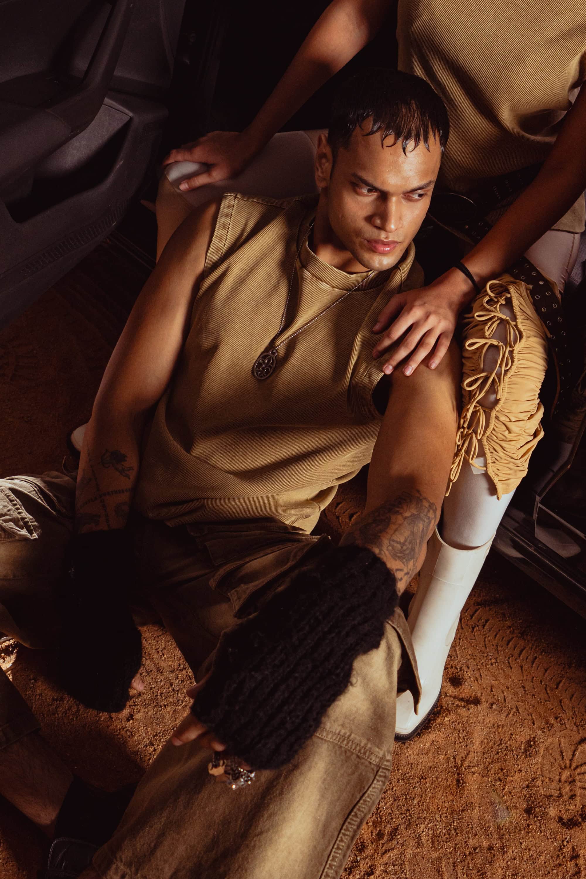 Model in relaxed fit beige tank top a casual outfit essential in men’s luxury streetwear